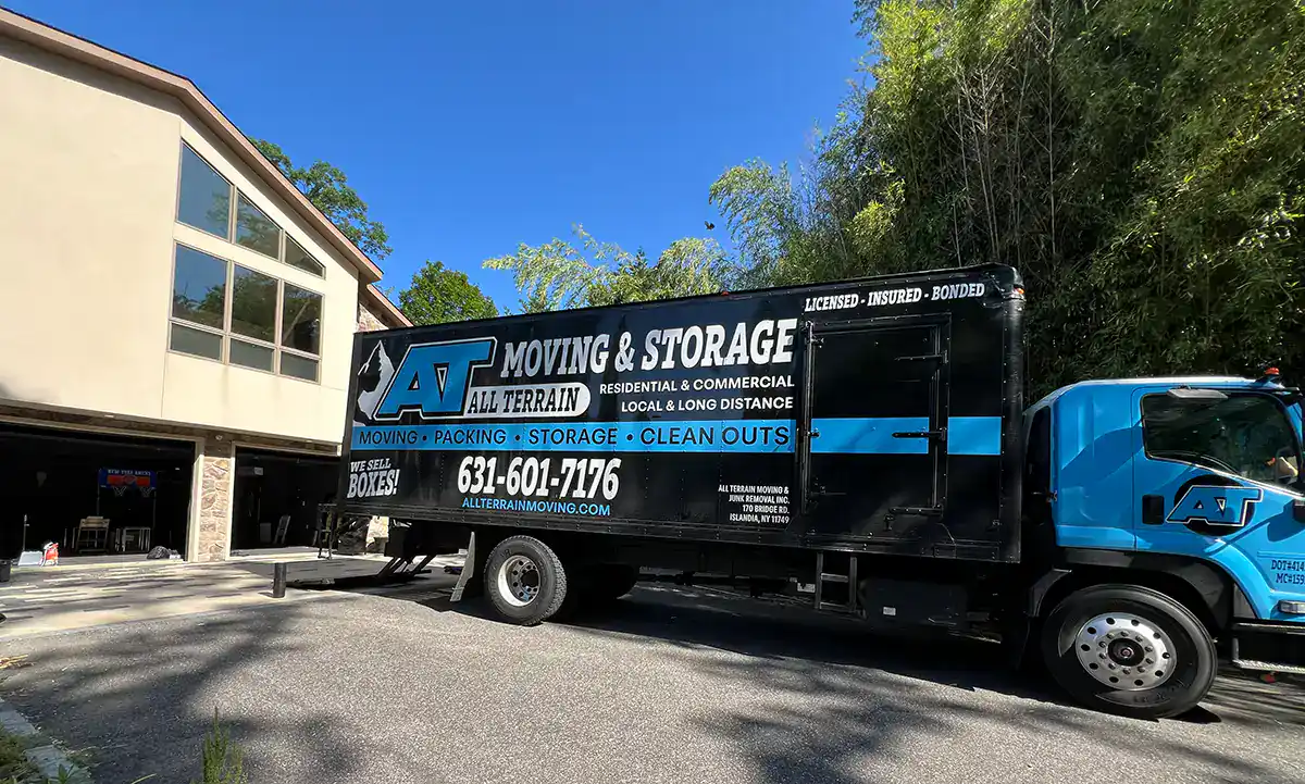 All Terrain Moving truck offering junk removal, storage, and moving services in a residential area.