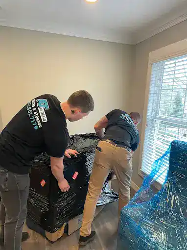 Moving and junk removal team at work in a residential interior.